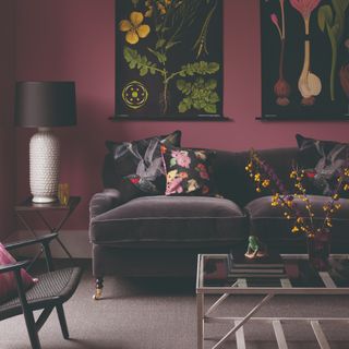 A berry-painted living room with botanical tapestries and a purple velvet sofa