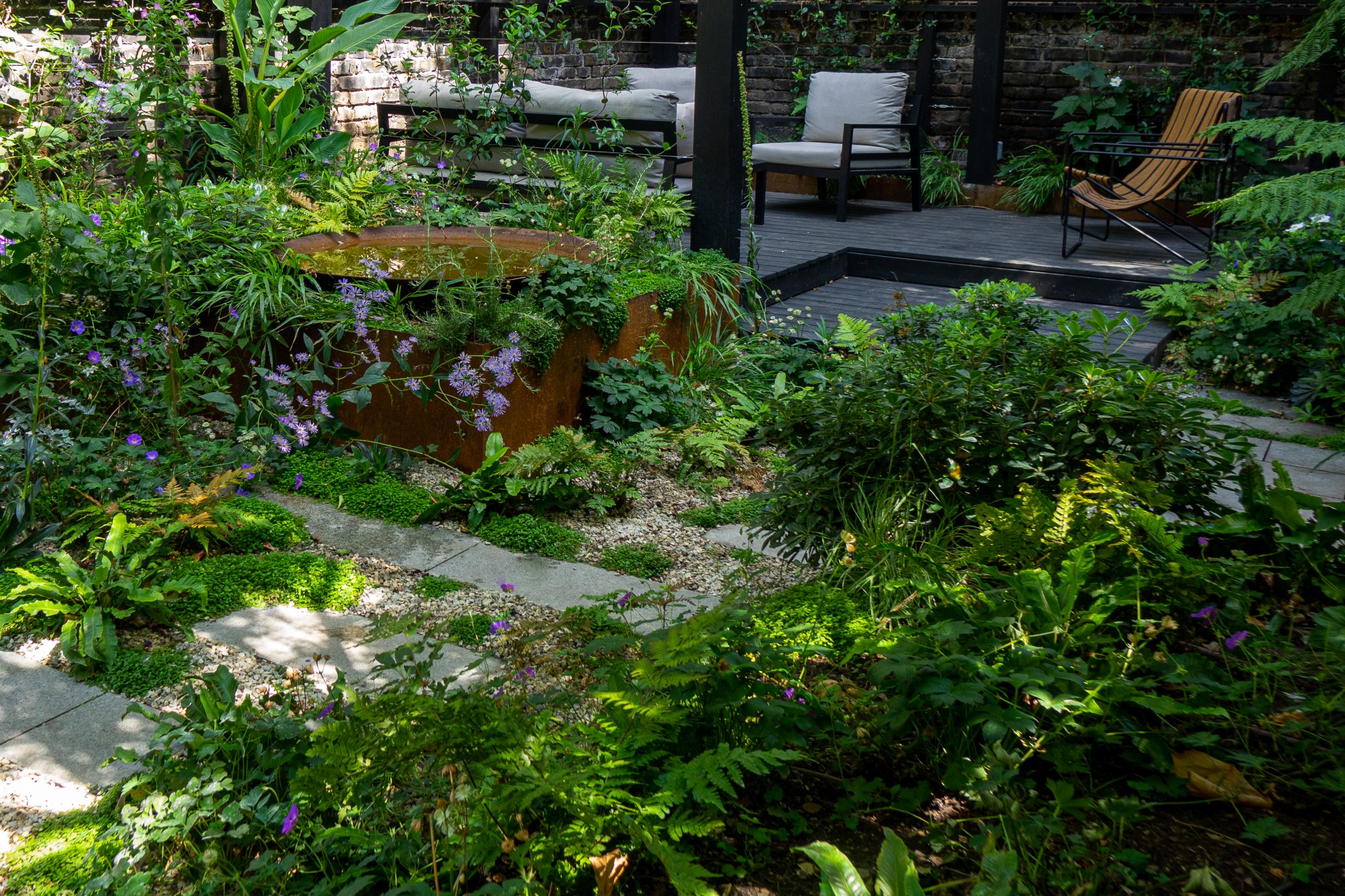 a garden with varying levels and a seating area at the back