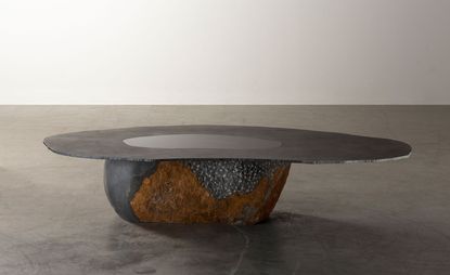 A table by Wonmin Park featuring a stone base and irregularly shaped steel top