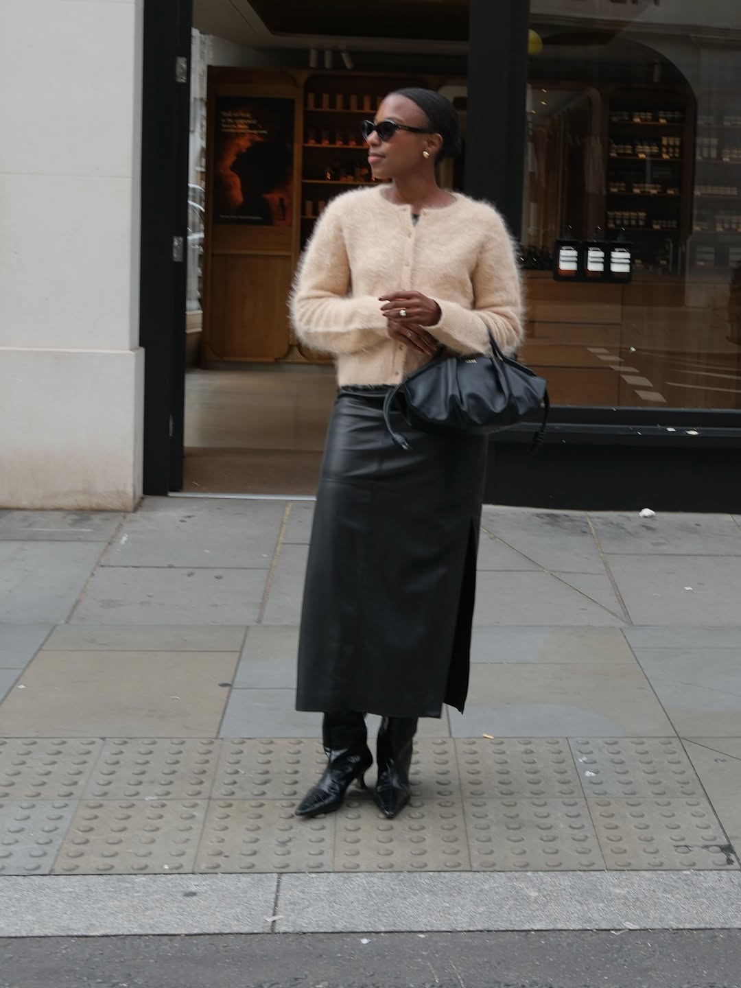 Woman wearing fall boots with skirt outfit 2025.