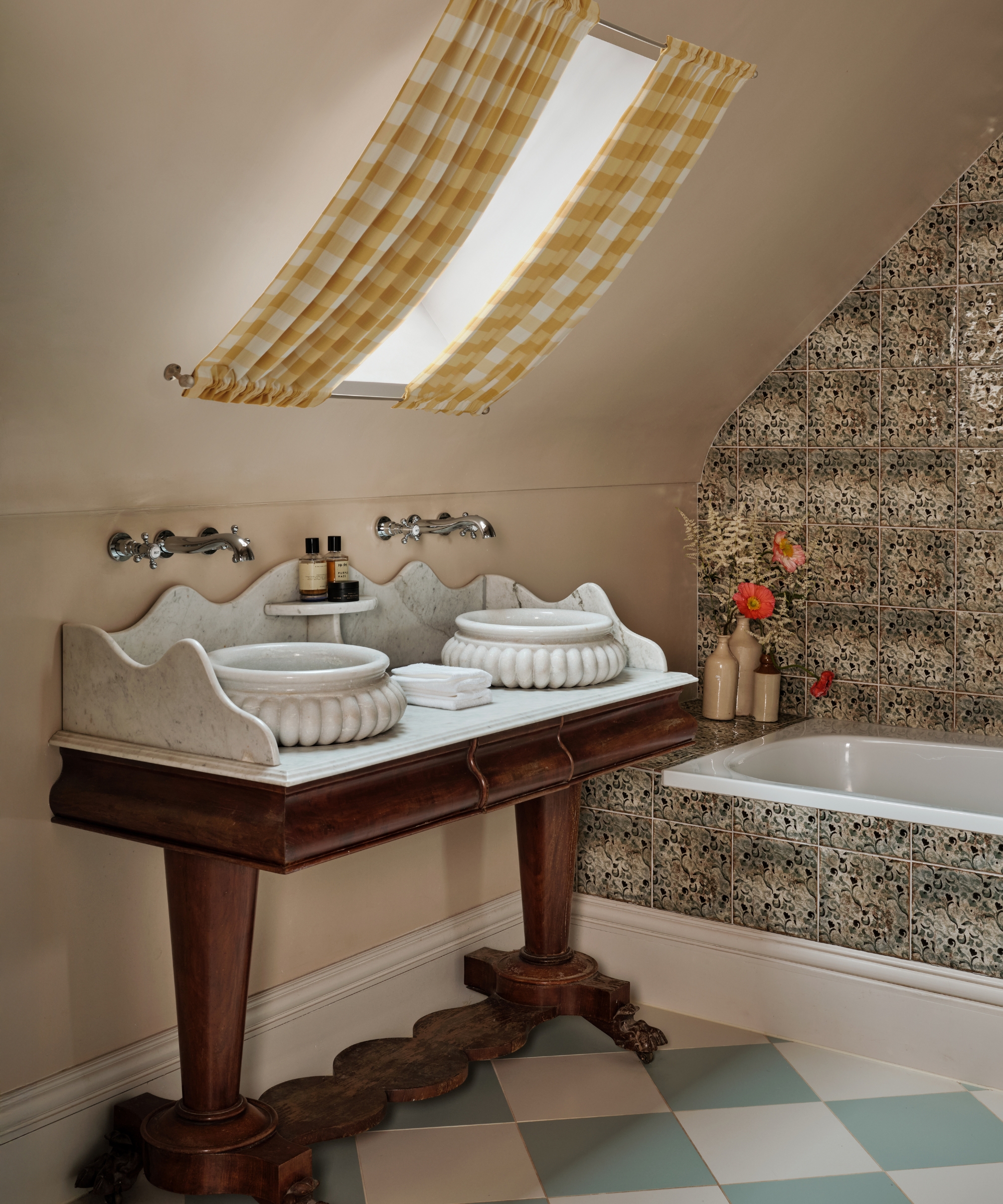 a loft bathroom with soft pink walls, a blue and white checkerboard floor, yellow gingham curtains, and a wooden vanity