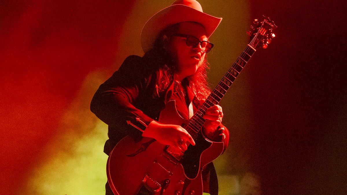 Bathed in red stage lights, Marcus King takes a solo on a vintage Gibson Barney Kessell signature model.