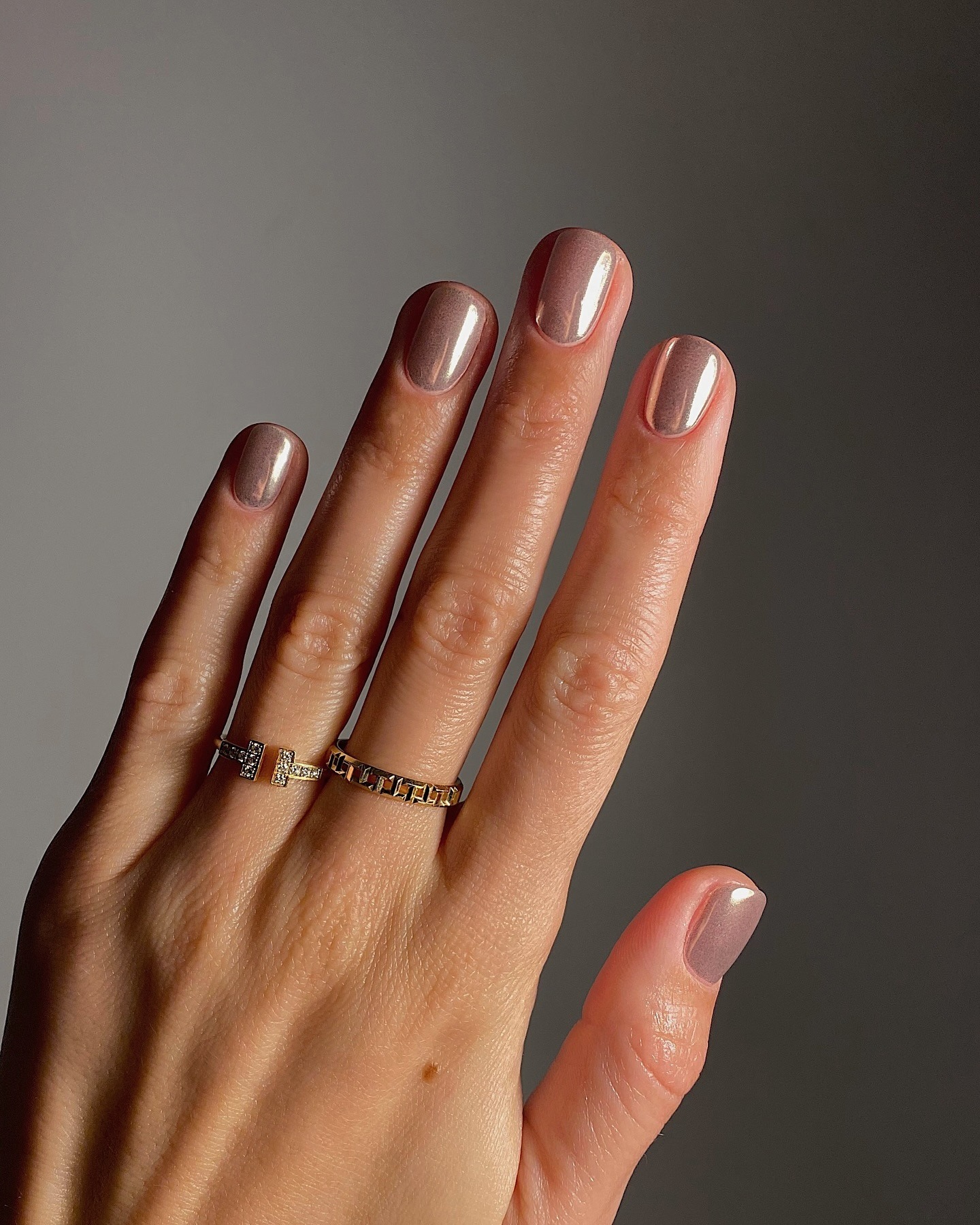Hands with short nails, painted with a silver chrome effect