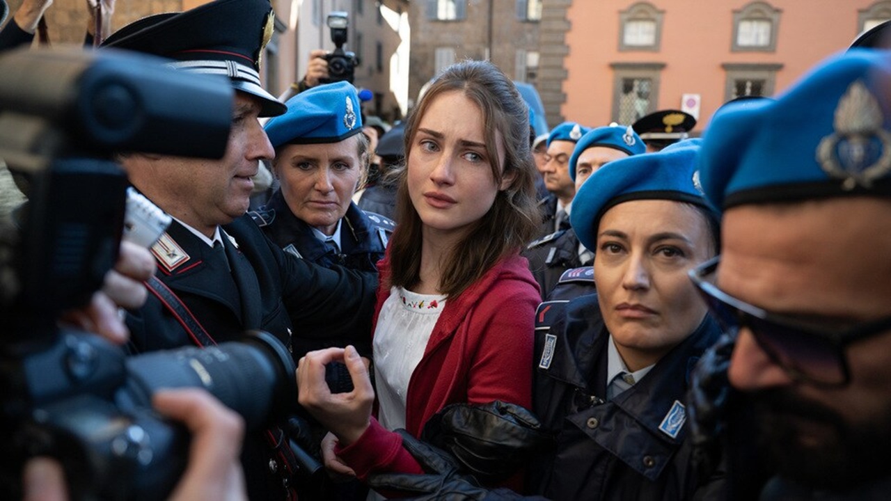 Amanda Knox (Grace Van Patten) is sandwiched between Italian police and press after her arrest for the murder of roommate Meredith Kercher in a scene from The Twisted Tale of Amanda Knox.