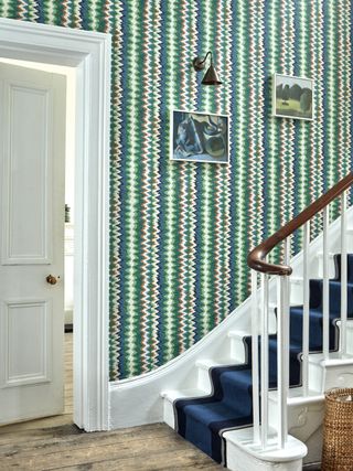Hallway covered in green and blue wallpaper by Amechi for Dado Atelier
