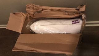 The Purple Harmony Pillow in its delivery box