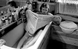 Richard Branson reading the paper in the bath