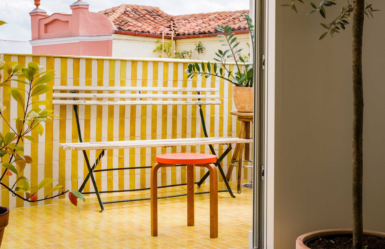 a balcony with yellow striped tiles