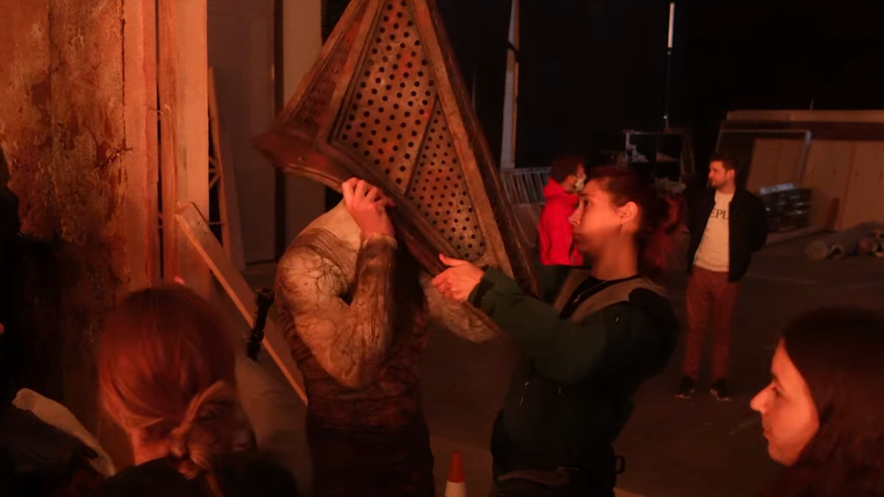 A crew member helps an actor put their Pyramid Head on in Return to Silent Hill.