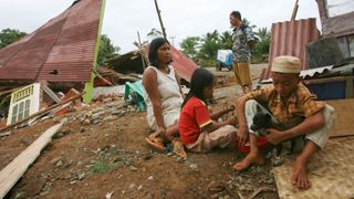 BENGKULU, SUMATRA ISLAND, INDONESIA - SEPTEMBER 13: A family sits near their quake damaged home in Lais village, about 50 km from Bengkulu City, on September 13, 2007, in Bengkulu province, Sumatra Island, Indonesia. At least 10 people have been killed, dozens injured and hundreds of homes and buildings damaged by a 7.9 magnitude earthquake which hit Sumatra yesterday, prompting a tsunami warning. The tremor was felt in neighbouring Singapore, Malaysia and Thailand, and triggered panic as far as East Africa. Powerful aftershocks have continued to hit Sumatra today.