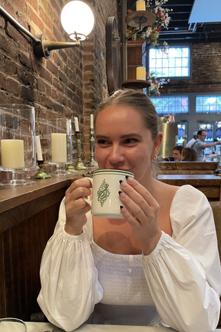 valeza drinking a mug of matcha green tea in a restaurant