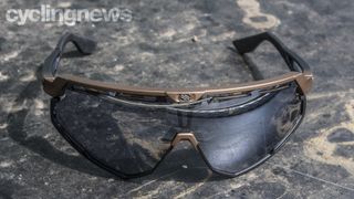 A brown and black pair of sunglasses on a black marble table