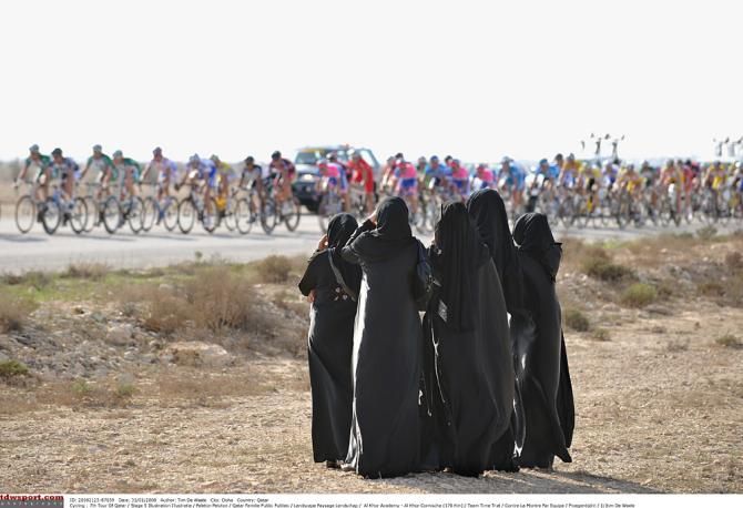 Locals watch the peloton speed past