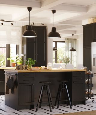 Black and white kitchen, black island with bar stools and storage rail on end, mini cart at other end, black pendant lights, black wall unit, Ikea,