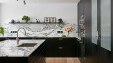 modern black kitchen with marble worktops and marble splashback