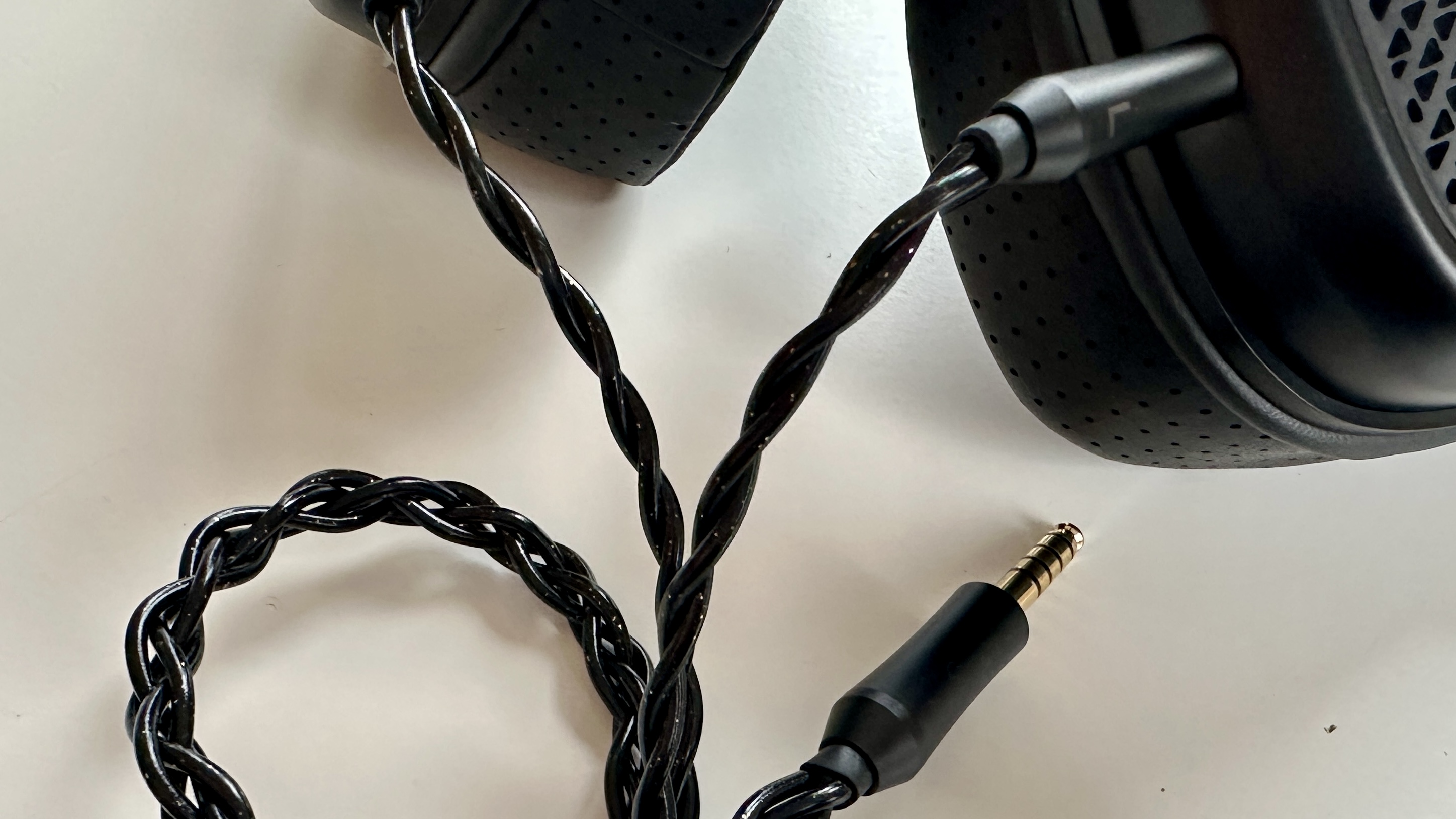 Shanling HW600 wired headphones, showing wired connections, on a white surface