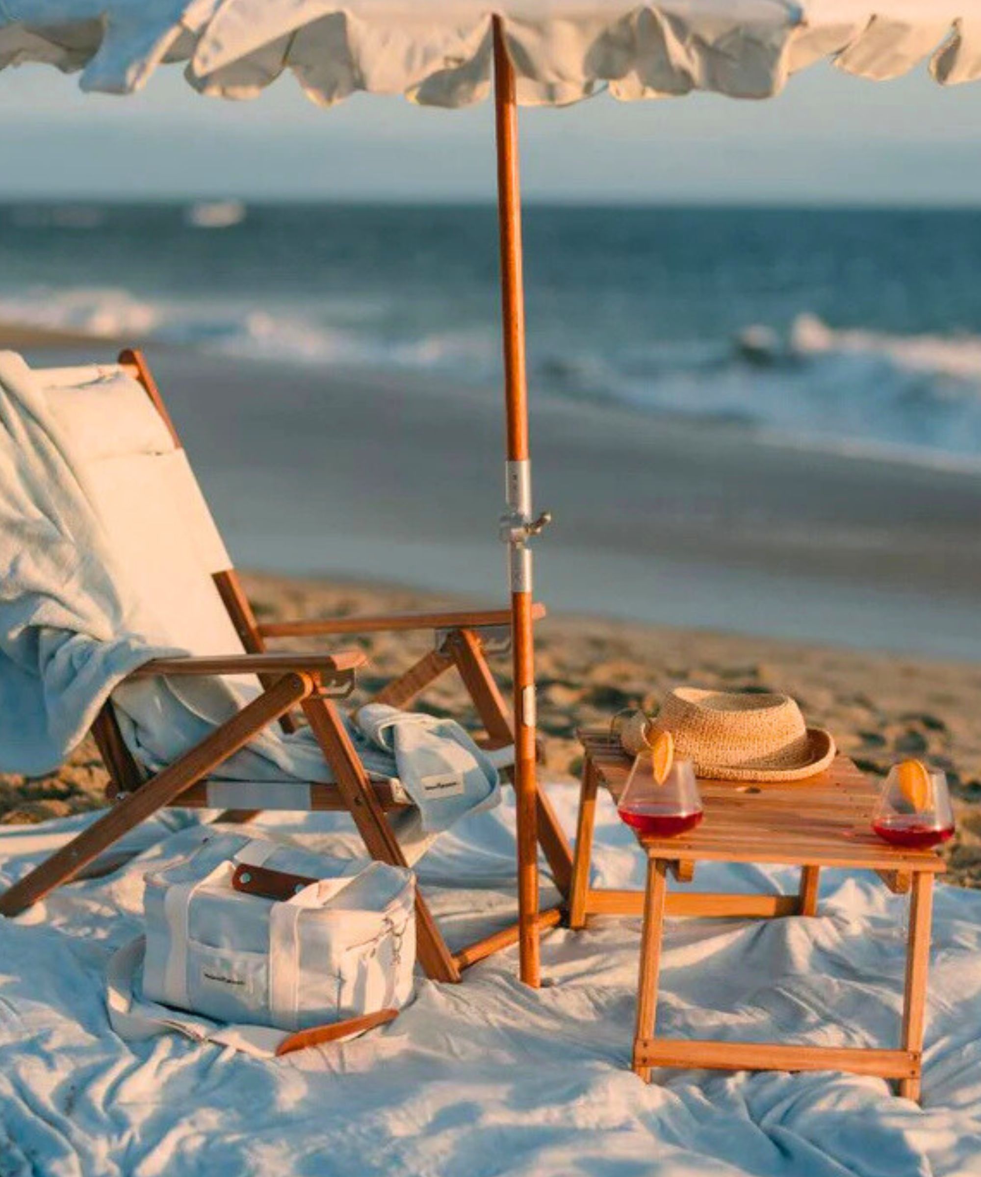 Business & Pleasure Co folding teak picnic table on a beach