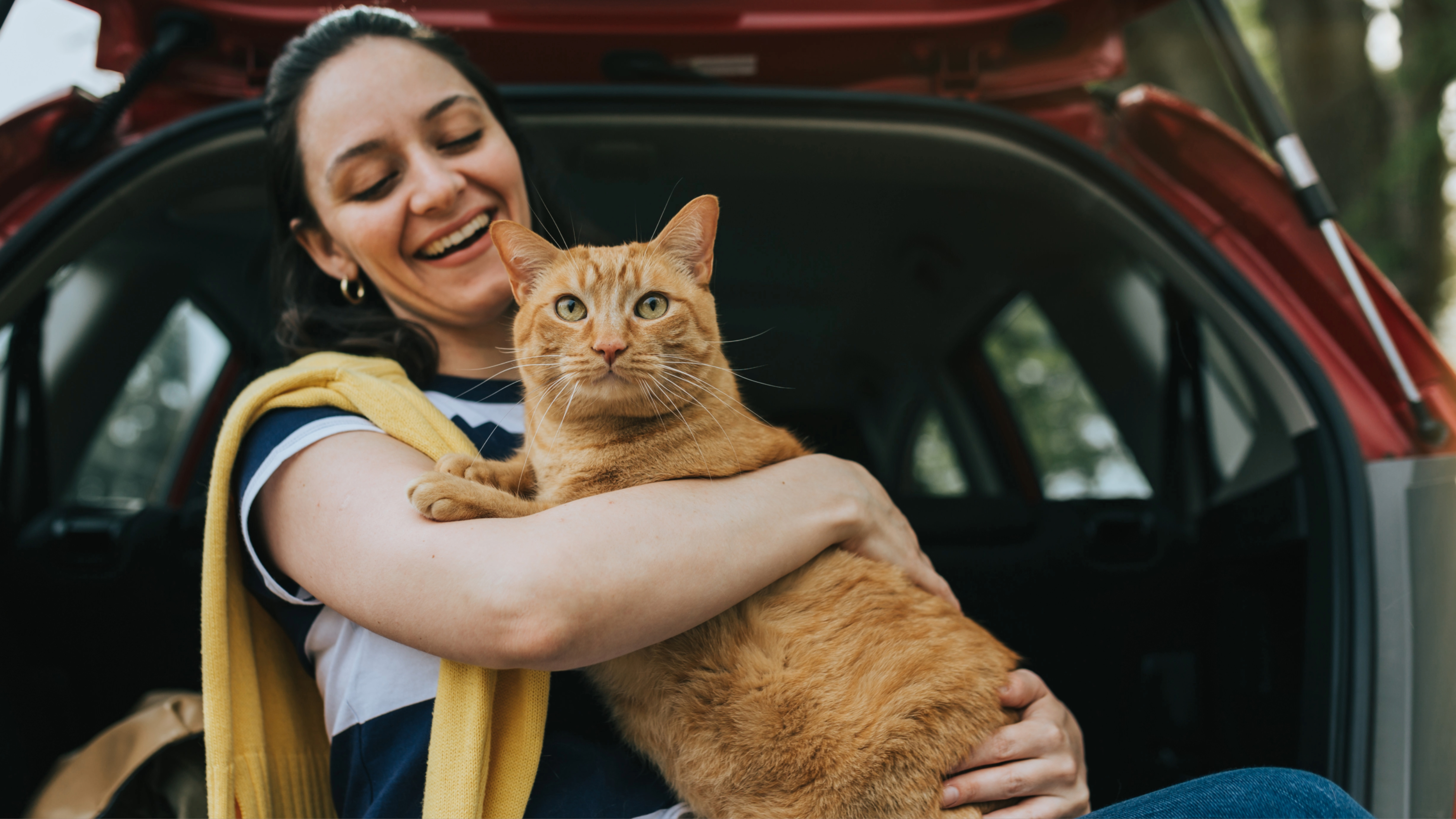Woman holding cat in car