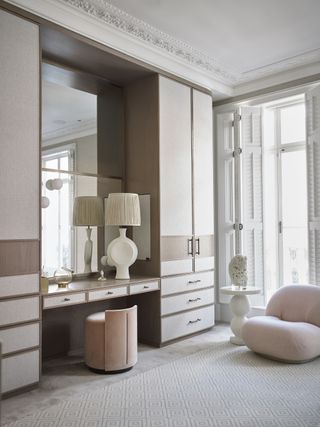 neutral and pink dressing room with bespoke wardrobes and vanity, 70s style furniture