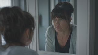 Faith (Kirsty Mitchell) looks at her reflection in Casualty