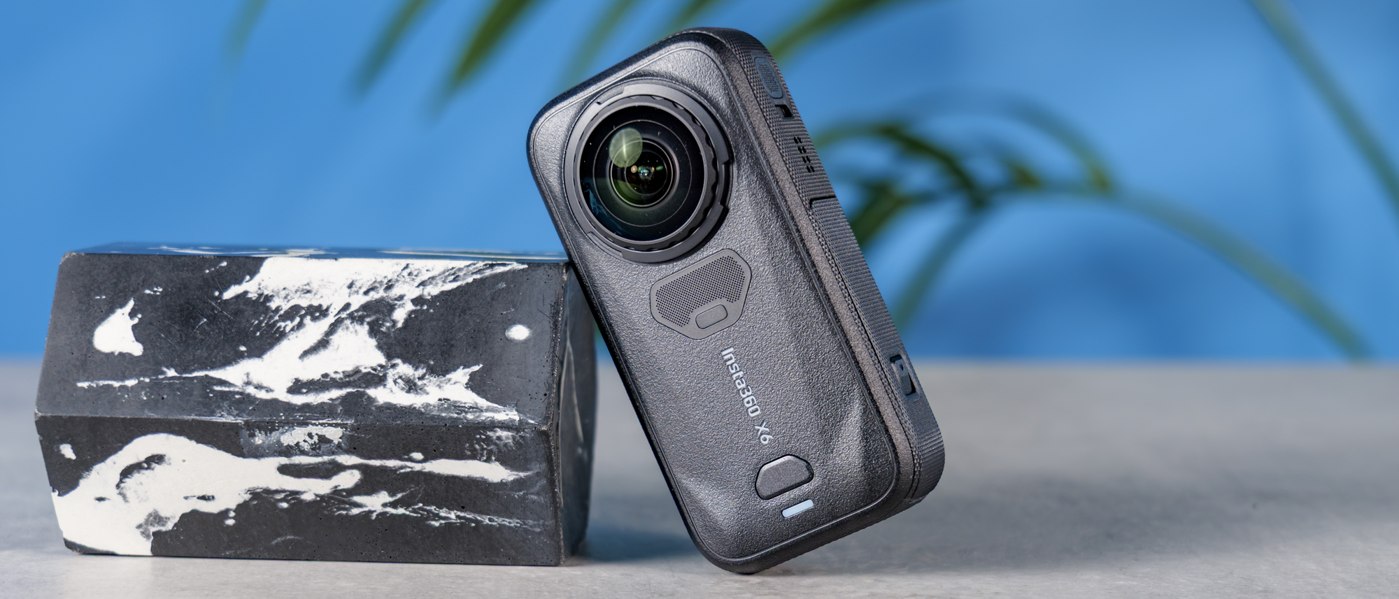 A photo of the Insta360 X6 on a stone surface, leaning on a marble plinth