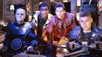 Still from the British sci-fi sitcom called Red Dwarf. Here we see four of the main cast sat in the cockpit of Starbug. From left to right: Kryten, The Cat, Rimmer, and Lister.