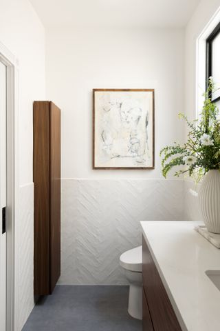 White bathroom with artwork hanging on wall