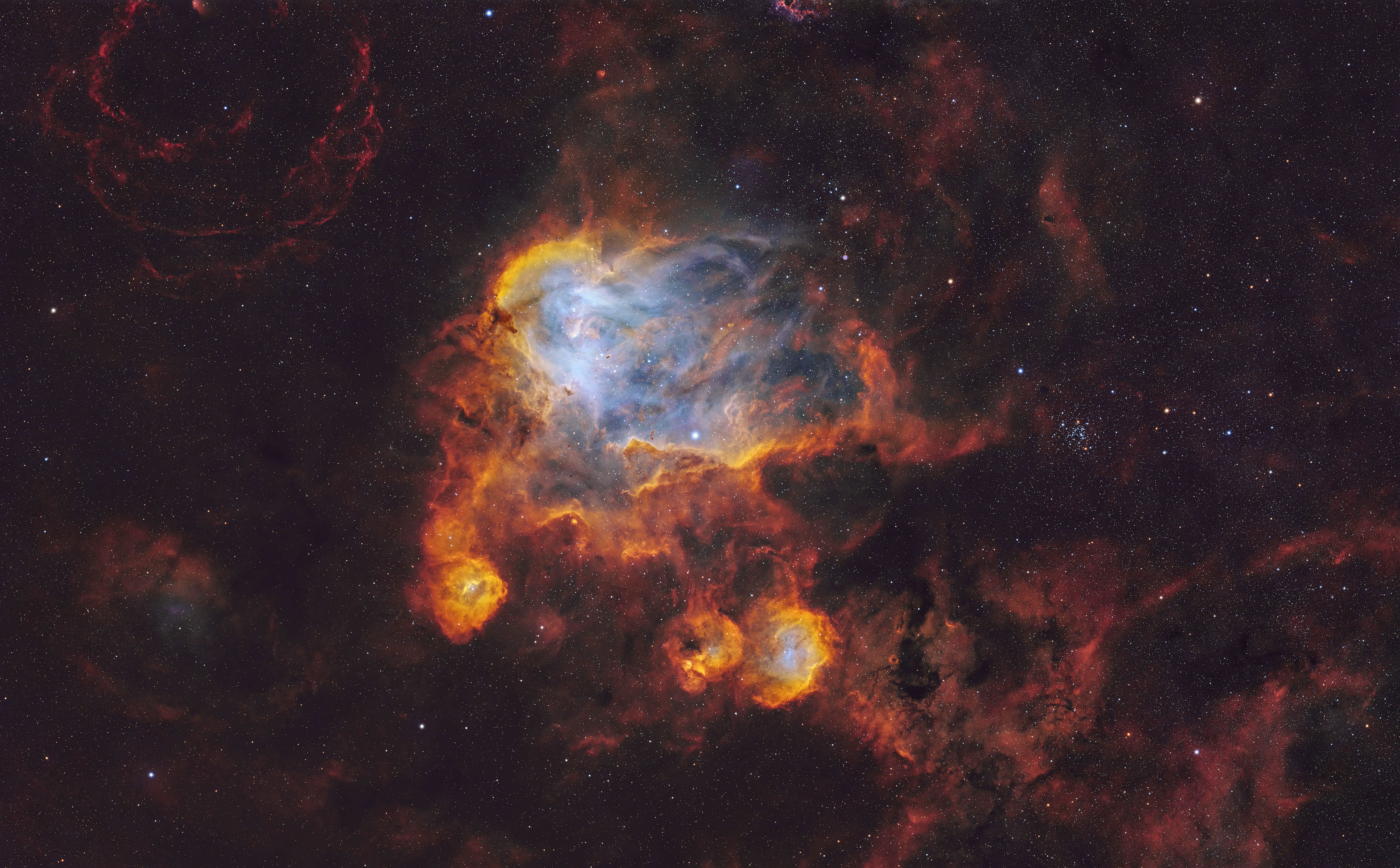 Clouds of blue and white swirl among darker nebula clouds of red and black in the darkness of space