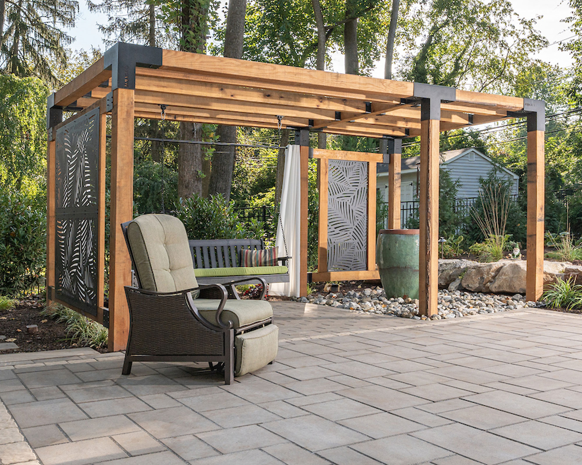 wooden pergola with decorative screens on patio with garden furniture