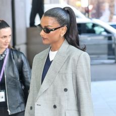 Simone Ashley wears a grey blazer with jeans and loafers.