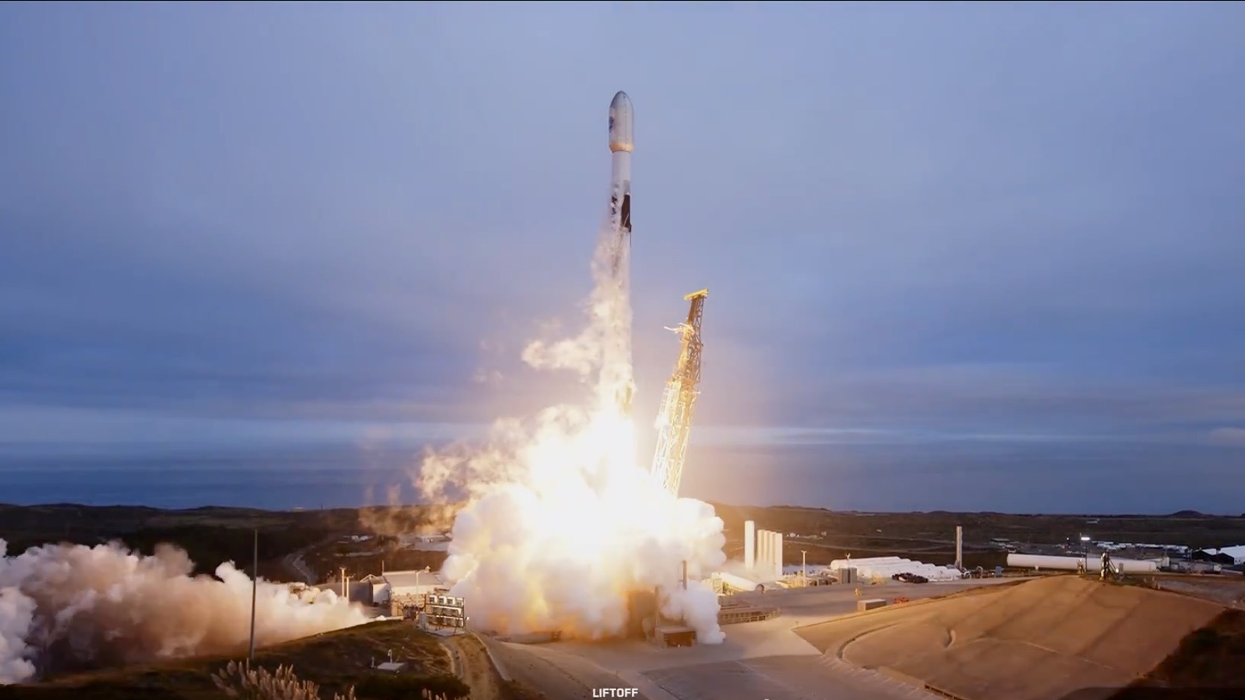 A rocket blasts off against a cloudy sky.