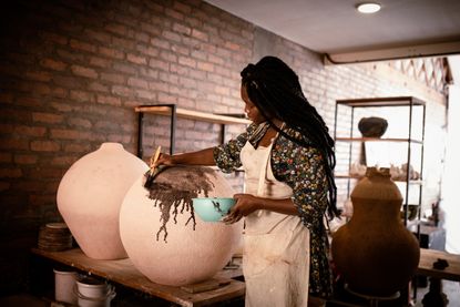 South African ceramicist Zizipho Poswa working on a piece from the iLobola collection for Southern Guild