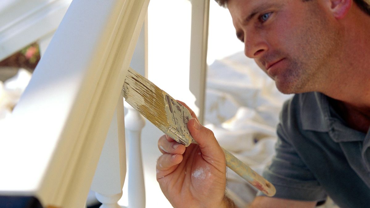 Person painting a banister white