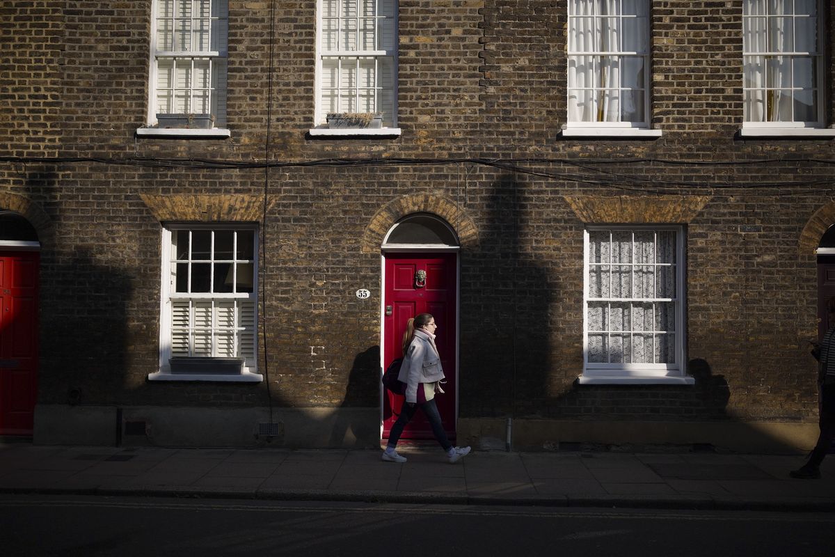 London street photo of people walking down old street in bright sunlight with strong shadows cast on the wall, taken with the Sigma BF camera and Sigma 35mm F2 DG lens