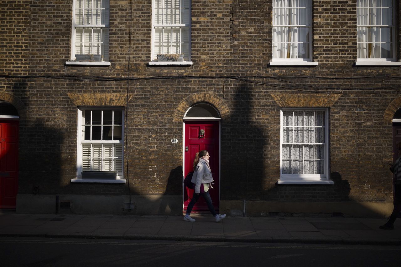 London street photo of people walking down old street in bright sunlight with strong shadows cast on the wall, taken with the Sigma BF camera and Sigma 35mm F2 DG lens