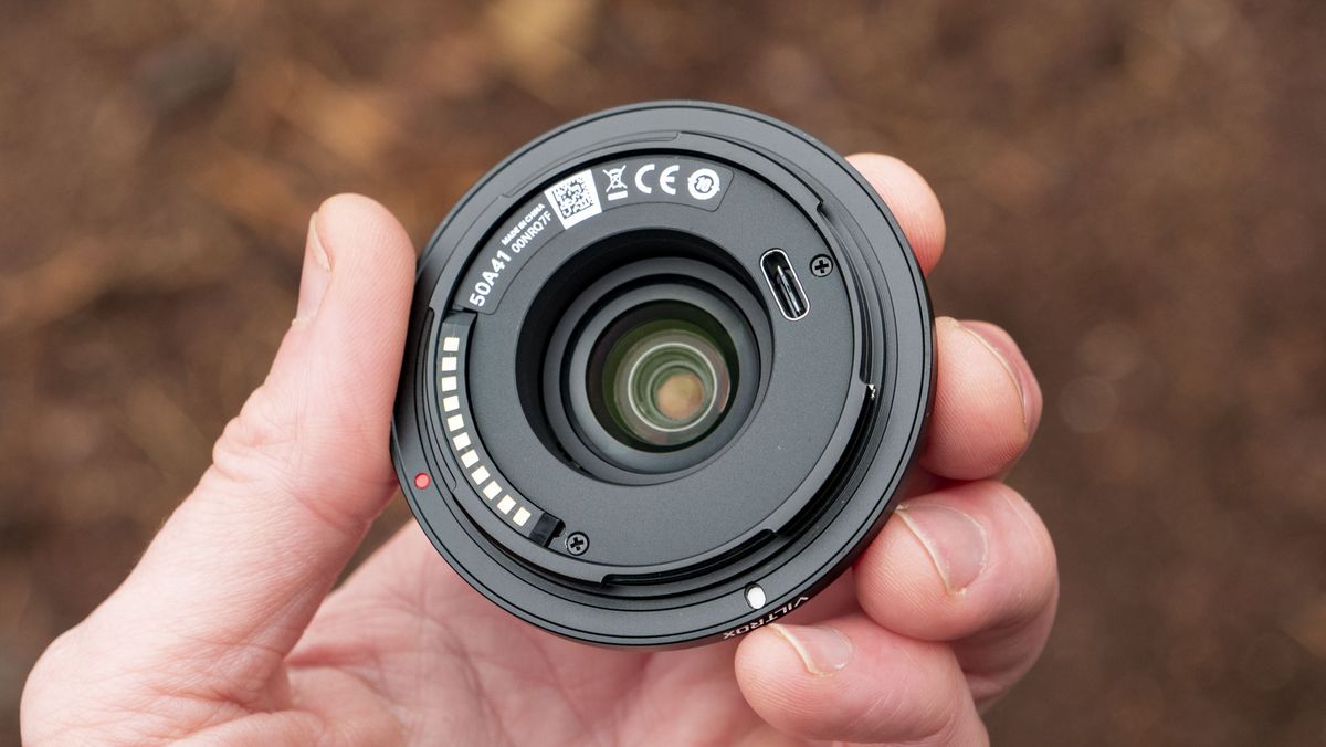 Viltrox AF 28mm f/4.5 body cap lens in photographer's hand