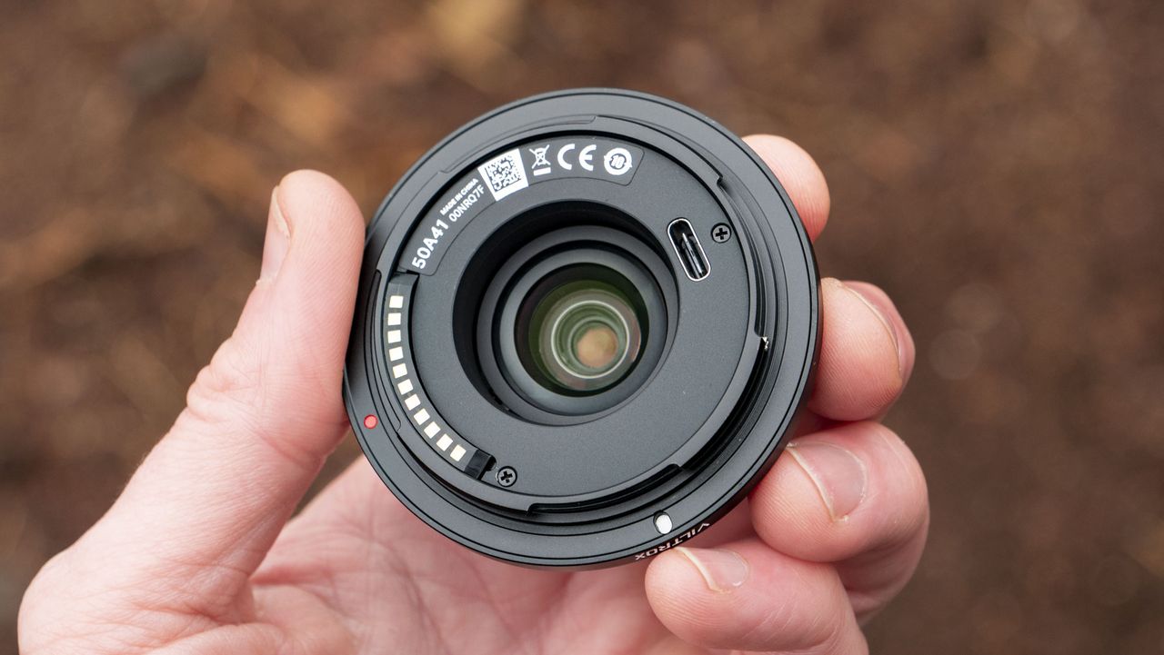 Viltrox AF 28mm f/4.5 body cap lens in photographer's hand