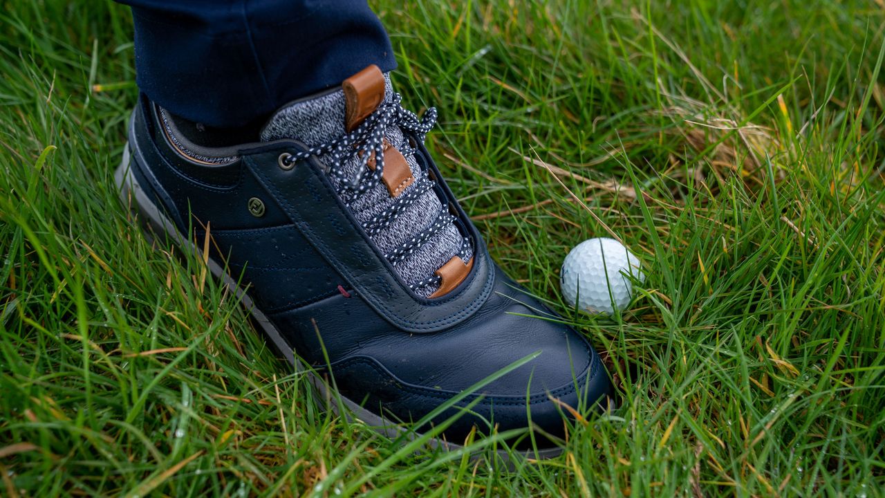 golfer kicking a golf ball into a better lie