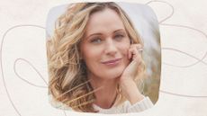 a midlife woman with blonde curly hair in a winter jumper, with clear skin