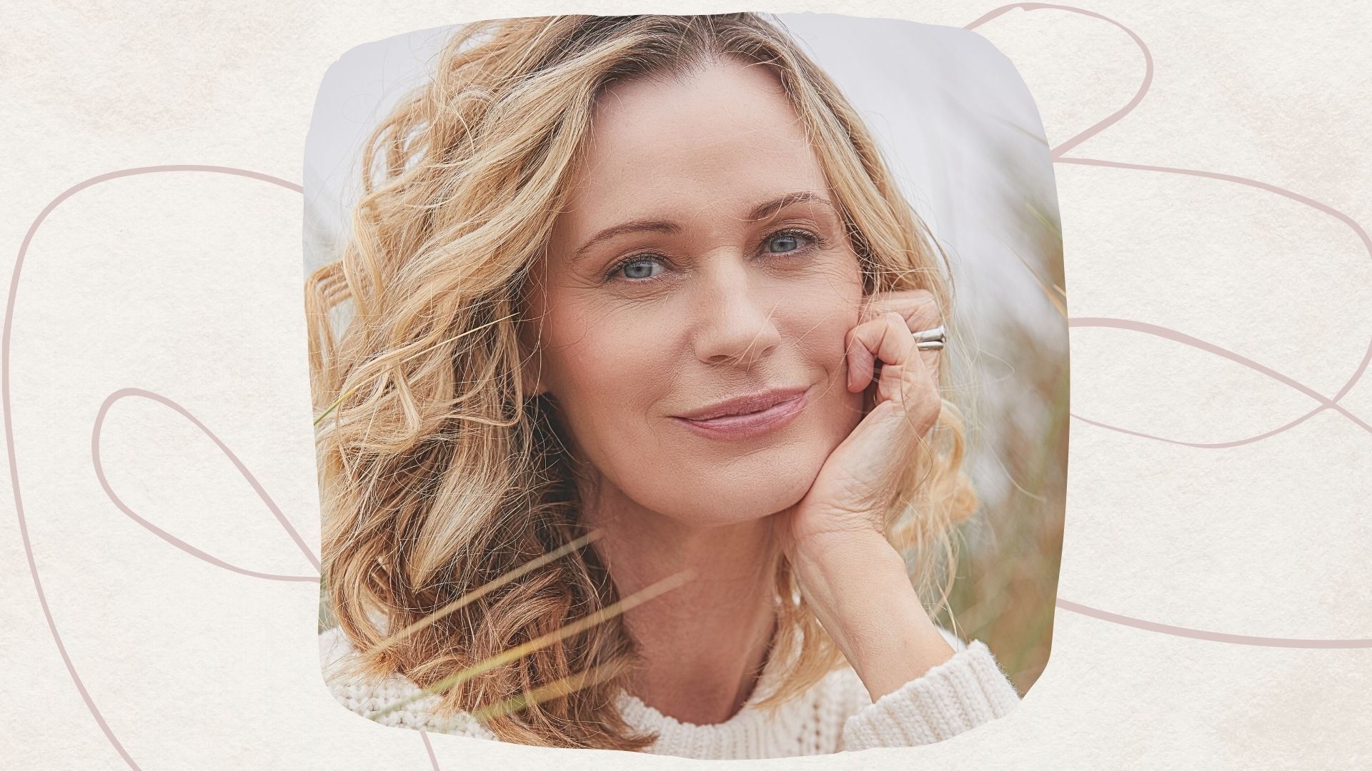 a midlife woman with blonde curly hair in a winter jumper, with clear skin 