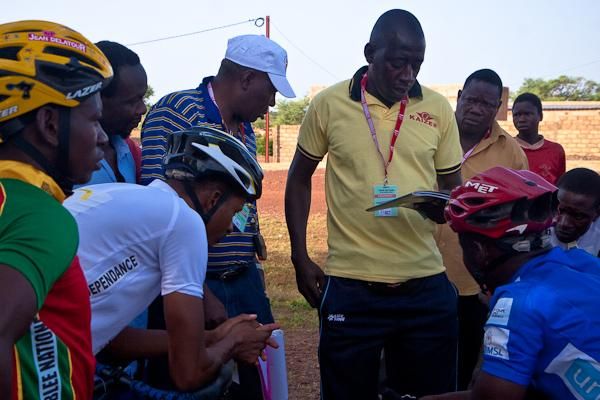 One of the Burkina Faso coaches discusses strategy with all of the Burkina teams. They have a significant numbers advantage, with 18 riders racing for three teams.