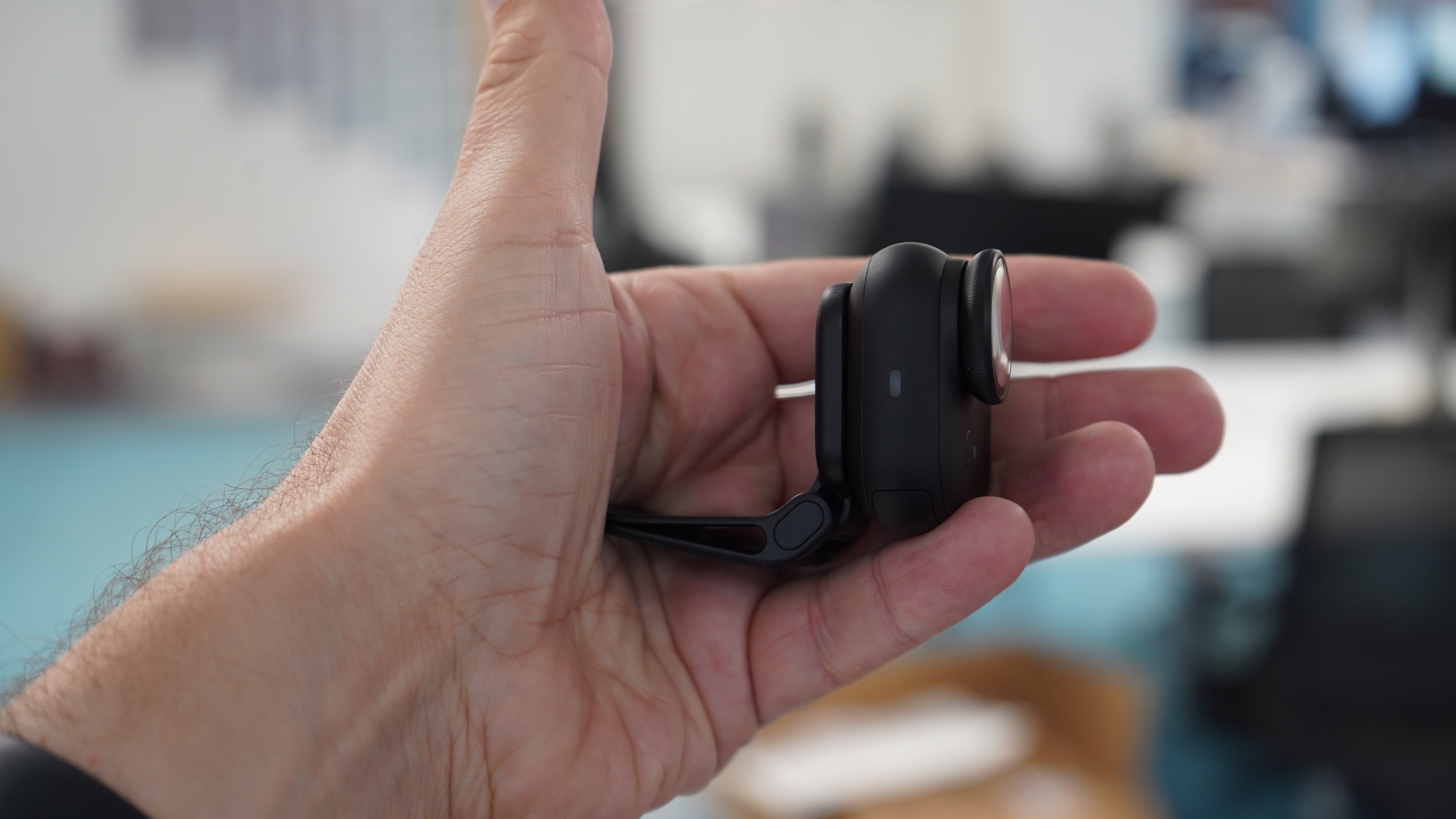 Insta360 Go Ultra on its magnetic clip in a hand