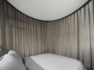bedroom behind curtain at InJoy Snow Hotel Bangkok by HAS design and research