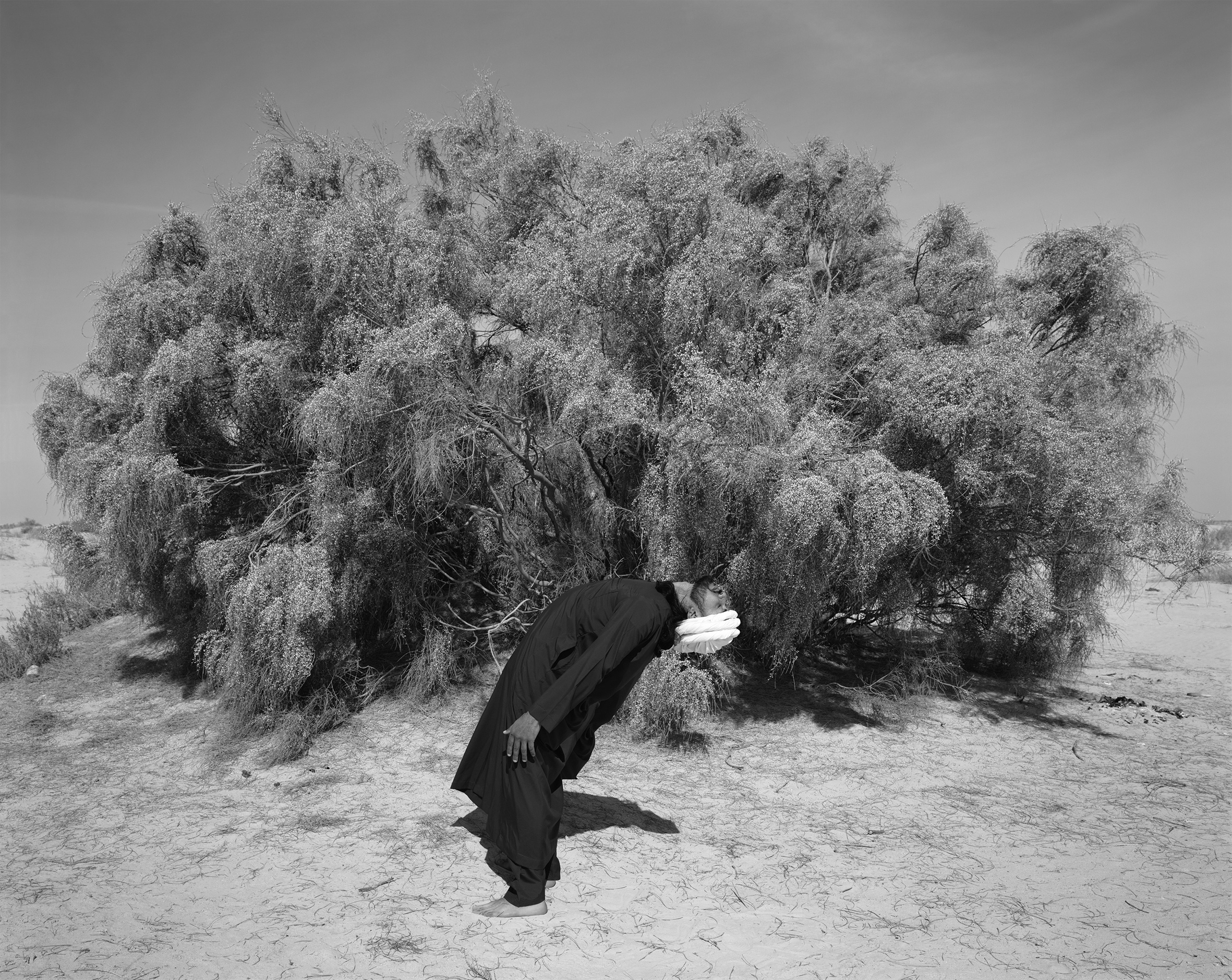 Black and white image of man in mask staring at the ground