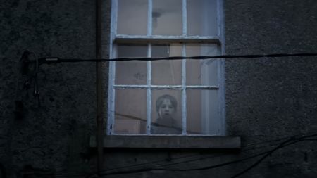 The child from The Hole in the Ground staring through the window