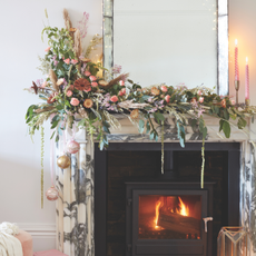 Large floral mantlescape on white mantle above a log fire