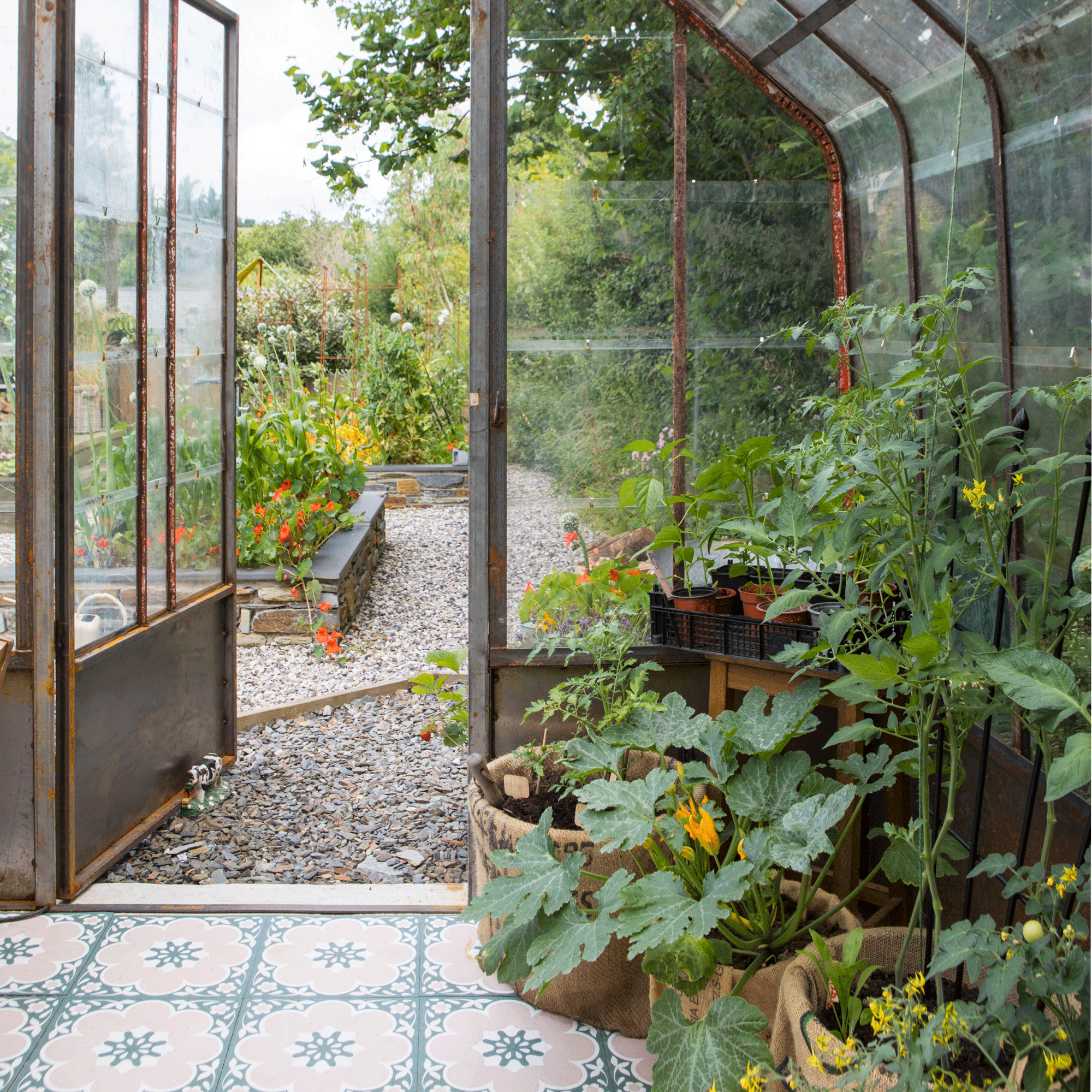 the view out from a greenhouse with a patterned tiled floor with container plans inside and out