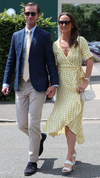 Pippa Middleton, wearing a yellow floral dress, and James Matthews, wearing a blazer, trousers and shirt, attend day 11, the Men's semi-finals at Wimbledon 2019