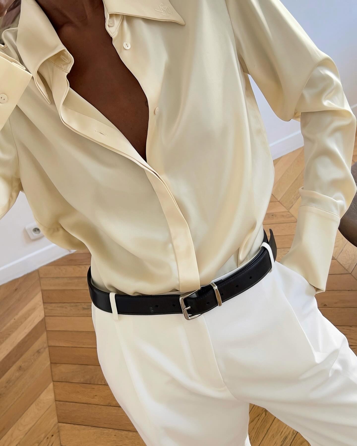 An image of @sylviemus_ wearing a buttery yellow satin blouse with white pleated trousers.