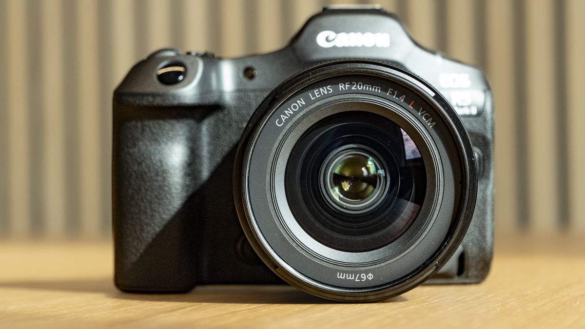 Canon RF 20mm F1.4L VCM lens on a wooden table, attached to the EOS R5 Mark II camera